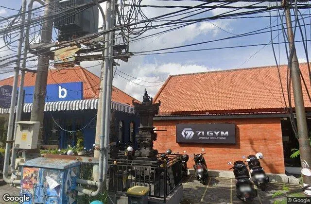 The 71 Gym signboard on a red-brick building in Umalas, scooters parked outside
