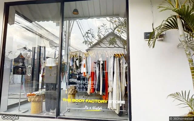 Glass shopfront of The Body Factory Store in Canggu, clothing racks visible inside
