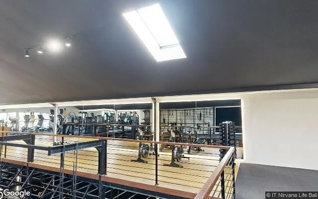 Mezzanine view inside Nirvana Life gym, Berawa: cardio machines, weight rig, dumbbell racks