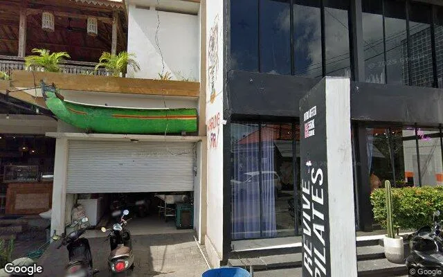 Black-fronted Revive + Pilates studio in Canggu, vertical white signage beside glass shopfront